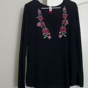 Black tunic with criss cross top and floral detail.